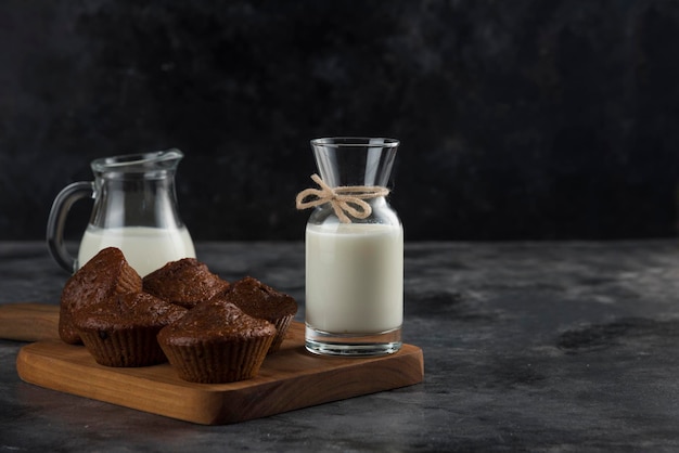 Lait et biscuits bruns sur planche à découper en bois