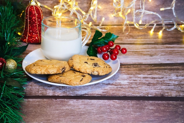 Lait avec des biscuits de noël pour le père noël sur une table en bois mise au point sélective