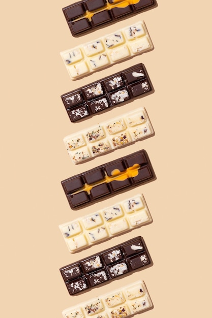 Lait blanc artisanal et motif de bonbons au chocolat noir sur fond beige vue de dessus à plat