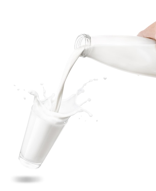 Le lait de la bouteille se versant dans le verre créant des éclaboussures isolé sur fond blanc