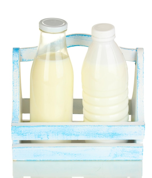 Photo lait en bouteilles dans une boîte en bois isolé sur blanc