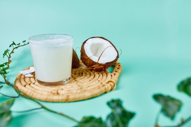 Photo lait de coco frais et sain dans un verre sur une surface verte