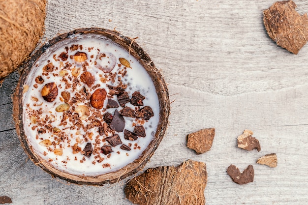 Lait de coco et granola dans une coque de noix de coco