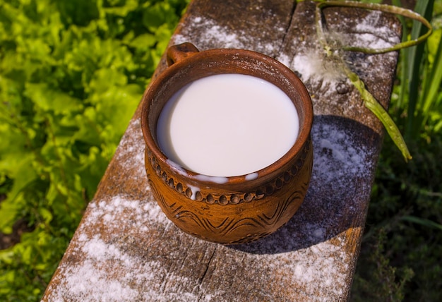 Lait dans une tasse sur une table en bois Lait dans une tasse vintage sur une vieille table en bois