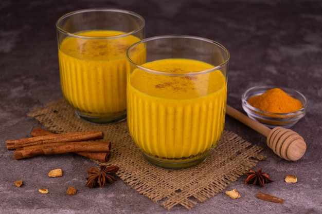 Lait doré à la cannelle et aux épices Deux verres de latte au curcuma Boisson végétalienne saine