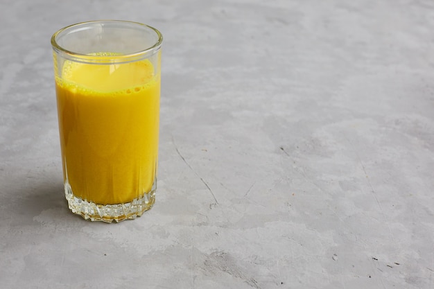 Lait doré dans un verre avec des additifs de curcuma et de miel.