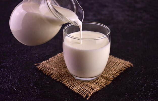 Le lait est versé dans un verre sur fond noir