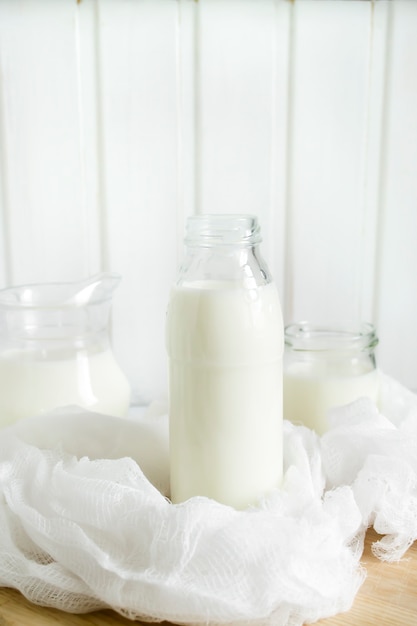 Photo lait frais en bouteilles de verre sur un fond en bois clair