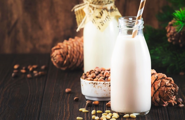 Lait de noix de cèdre en bouteilles fond de bois Lait végétalien alternatif non laitier et pommes de pin Nourriture et boisson végétariennes saines