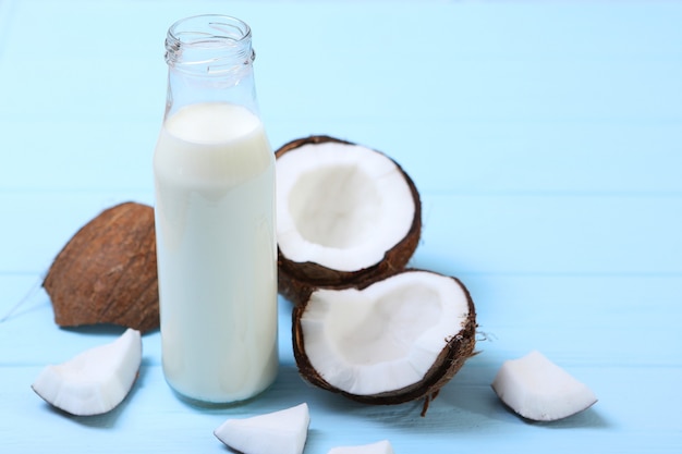 Lait et noix de coco cassées sur la table lait végétal une boisson végétarienne