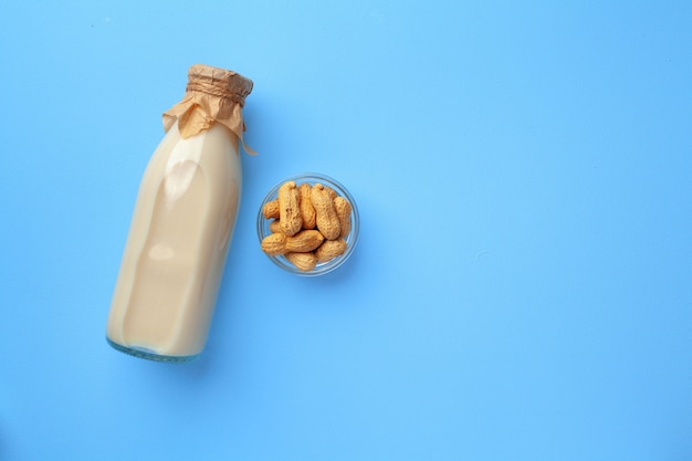 Lait non laitier d'arachide en bouteille en verre avec bol d'arachides