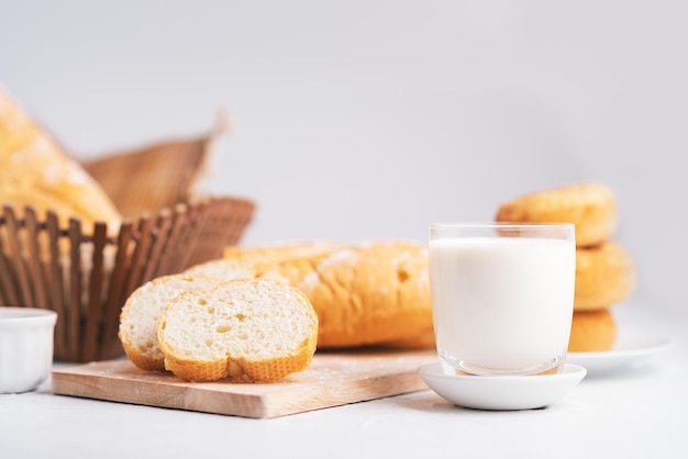 Lait et pain sur une table en bois blanche, espace de copie, petit-déjeuner