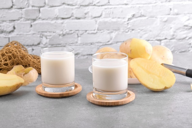 Lait de pomme de terre végétalien et pomme de terre sur fond de table en pierre grise Substitut de lait alternatif à base de plantes et sans lactose