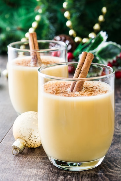 Lait de poule fait maison à la cannelle sur une table en bois Dessert typique de Noël