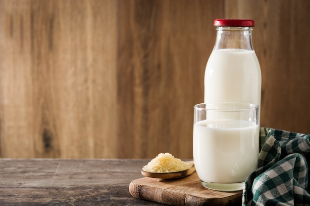 Lait de riz en verre et bouteille sur une table en bois.