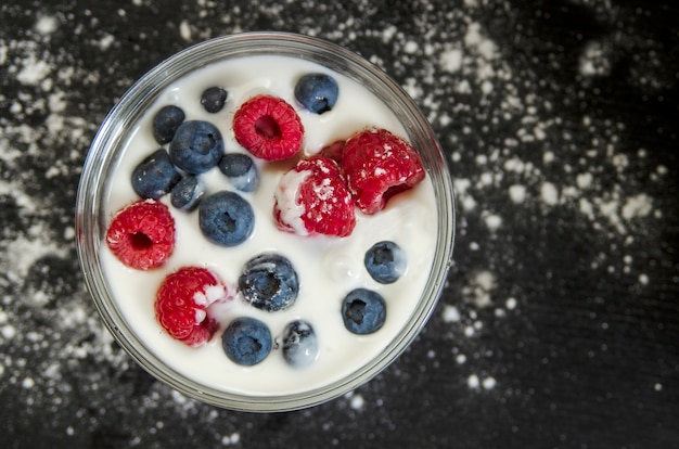 Lait de soja ou de jogurt avec framboise et myrtille, d&#39;en haut.