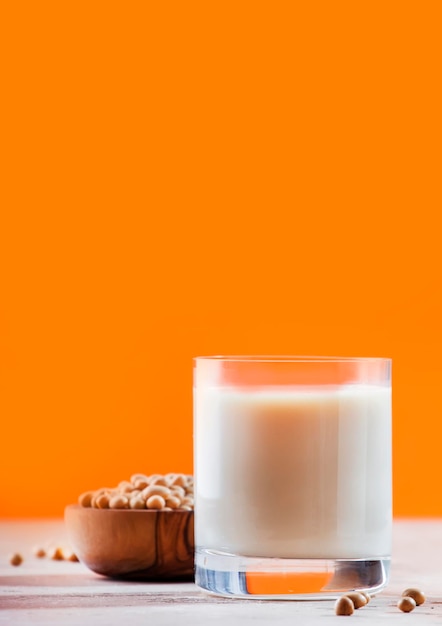 Lait de soja et soja sur fond orange Concept de lait non laitier Boisson végétalienne Copier l'espace