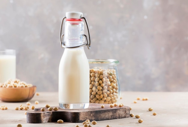 Lait de soja et soja sur table grise Concept de lait non laitier Boisson végétalienne Espace de copie