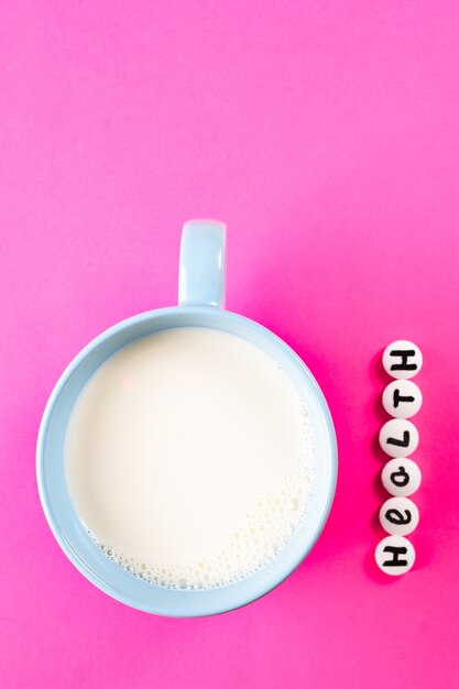 Lait En Tasse Bleue Et Inscription Santé Faite De Pilules Médicales Blanches Sur Un Espace Rose Vif