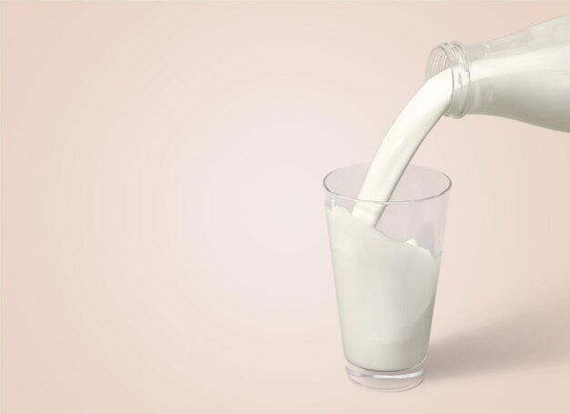 Lait versé dans le verre sur fond clair