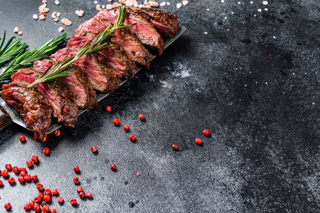 Lame supérieure grillée, steak Denver. Boeuf à la viande de marbre. Fond noir. Vue de dessus. Espace copie