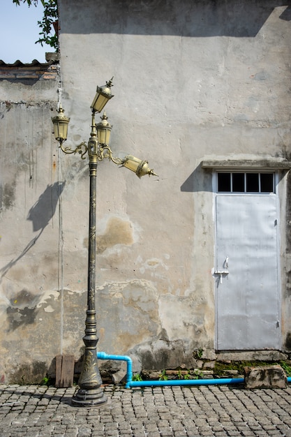 Lampadaire Ancien Et Cassé Avec Mur En Béton Et Porte En Métal En Arrière-plan.