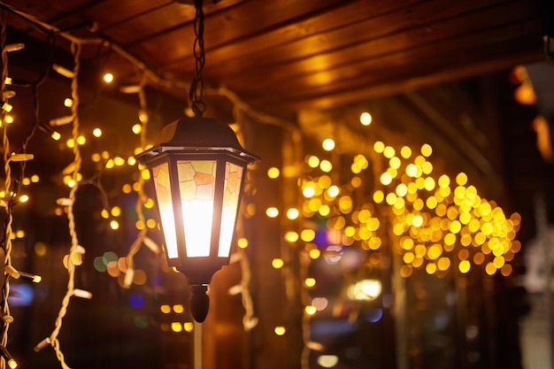 Lampadaire avec de la neige dessus sur fond de guirlandes festives