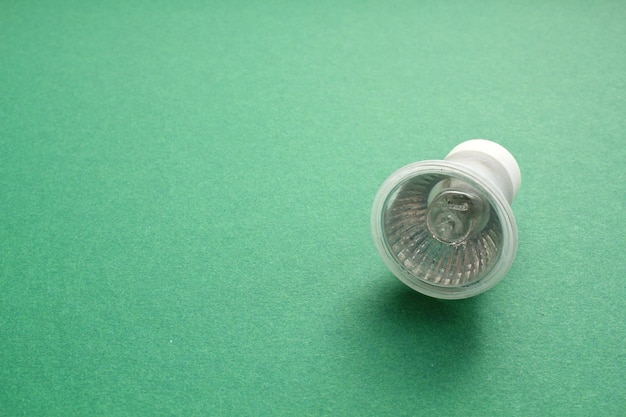 Lampe à ampoule LED électrique sur fond vert avec espace de copie. Économie d'énergie et environnement