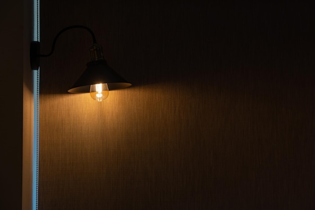 une lampe électrique vintage avec une ombre de style rétro éclaire un vieux grenier en briques