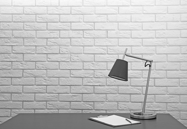 Lampe moderne sur le bureau sur fond de mur blanc