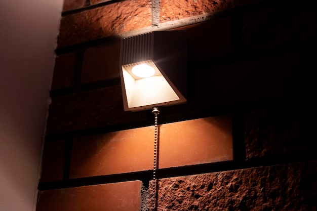 Lampe moderne sur un mur de briques rouges