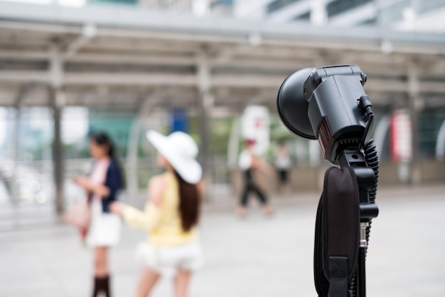 Lampe de poche noire photographique avec modèle de jeune femme floue pose en milieu urbain