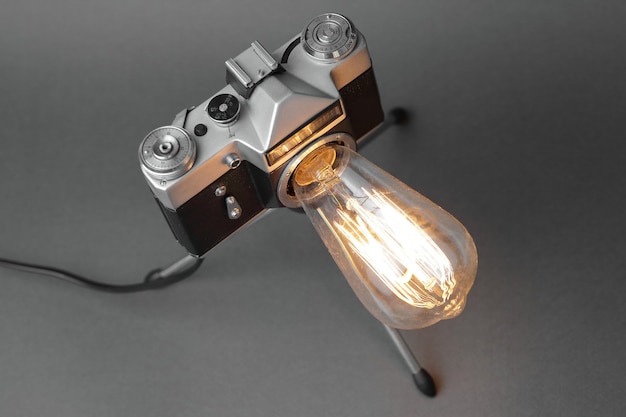 Lampe rétro d'un vieil appareil photo avec une lampe Edison sur gris