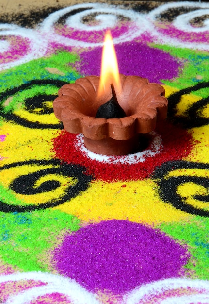 Lampes en argile diya allumées pendant la célébration de Diwali, Rangoli en arrière-plan