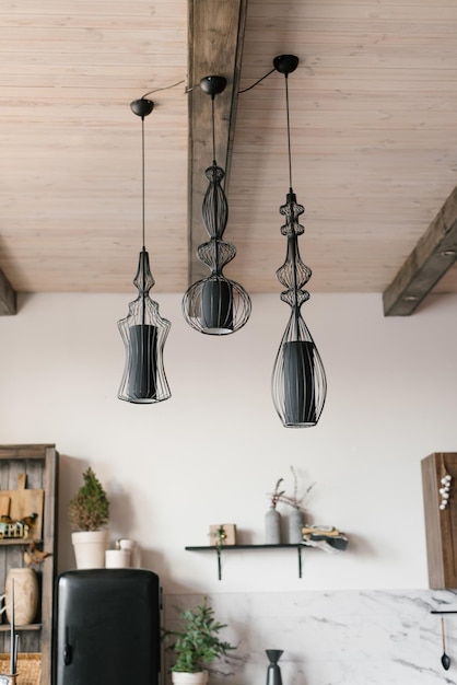 Lampes noires modernes au plafond à l'intérieur d'une maison de campagne en bois