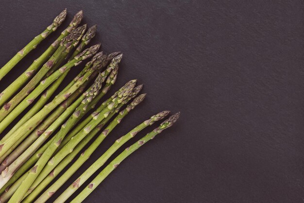 Lances d'asperges vertes crues fraîches sur l'espace de copie de fond noir