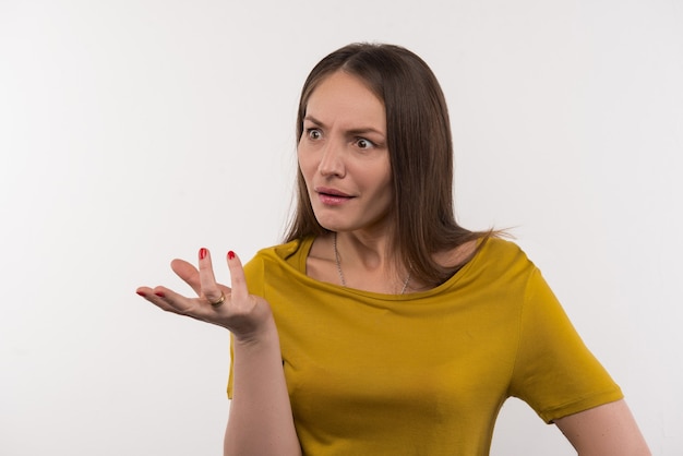 Le langage du corps. Belle femme émotionnelle debout sur fond blanc et gesticulant avec ses mains