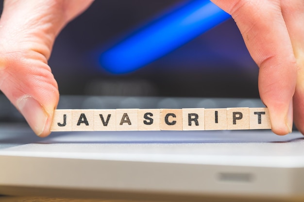 Langage Web de programmation Javascript Cubes en bois avec des lettres JAVASCRIPT allongé sur un concept d'ordinateur portable