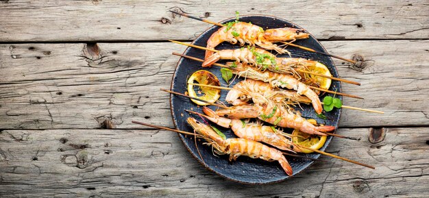 Langoustines grillées, crevettes rôties sur une brochette.Assiette de fruits de mer grillés.Copy space