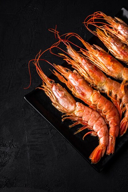 Photo langoustines sur une plaque libre tourné sur fond noir