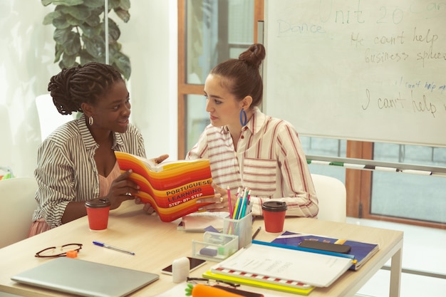 Photo une langue étrangère. jolie fille exprimant sa positivité tout en apprenant le portugais