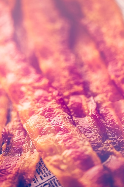 Lanières de bacon cuites sur un journal.