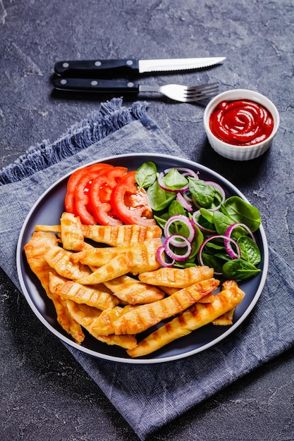 Lanières de poulet grillé sur une assiette avec des légumes