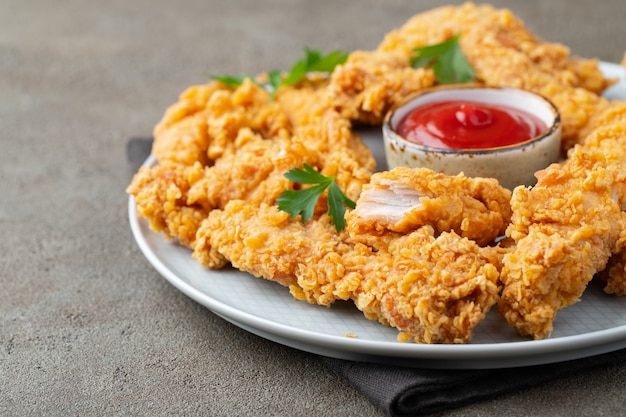 Lanières de poulet panées avec deux sortes de sauces.