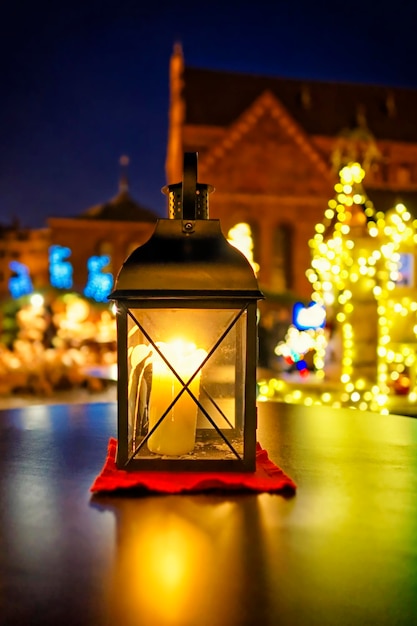 Lanterne avec bougie au marché de Noël européen devant l'arbre de Noël et la cathédrale