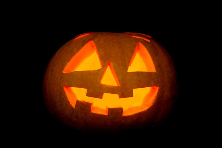 Photo lanterne de citrouille d'halloween effrayante rougeoyante sur fond noir.