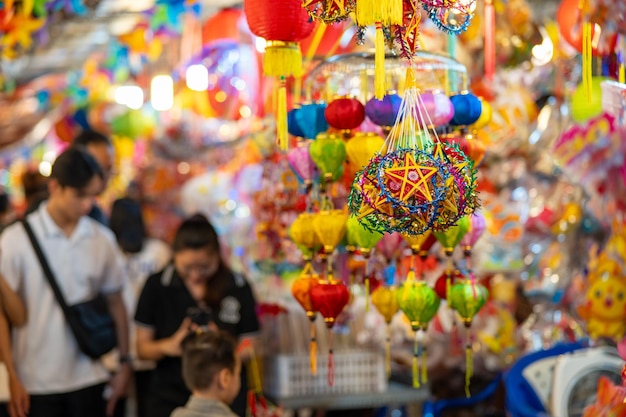 Lanternes colorées décorées accrochées sur un stand dans les rues de Hô Chi Minh-Ville au Vietnam pendant le festival de la mi-automne. La langue chinoise sur les photos signifie argent et bonheur Mise au point sélective