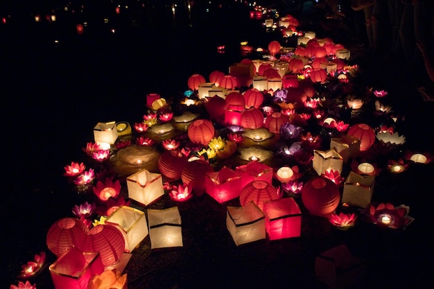 Lanternes en papier flottantes sur l'eau la nuit.