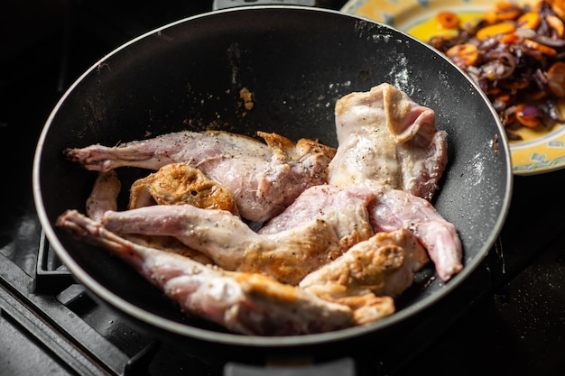 Lapin cru aux épices dans une casserole Cuisson du lapin mijoté