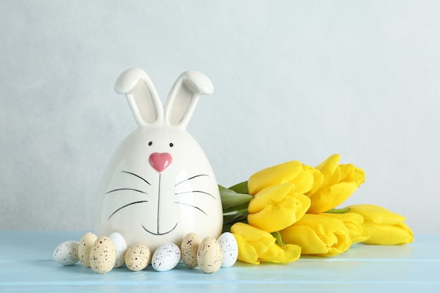 Lapin décoré et oeufs de Pâques sur table sur fond de couleur